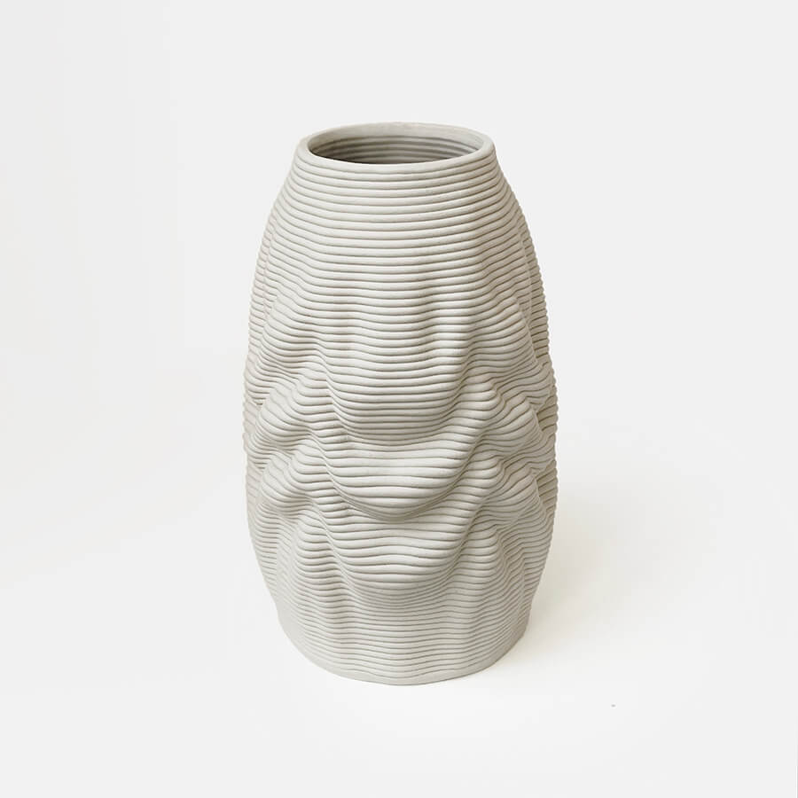 The tough stoneware body embodies the illusion of a soft, melting object, inviting viewers to contemplate the interplay between solidity and fluidity. The natural clay material exudes a warm and earthy aesthetic, further enhancing its organic appeal of this 3d printed vase.
